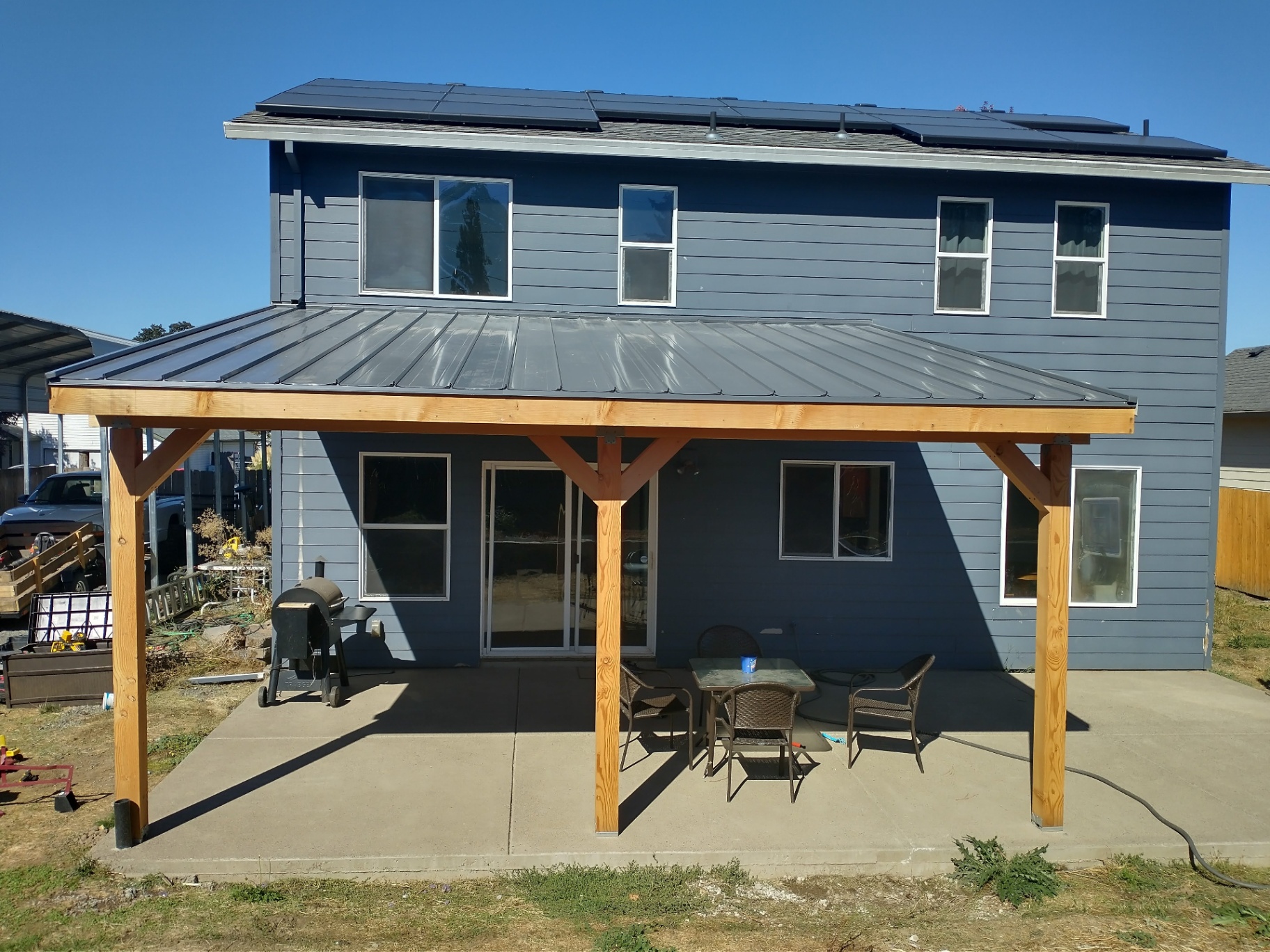 Custom covered patio with solar panels by Clean Construction